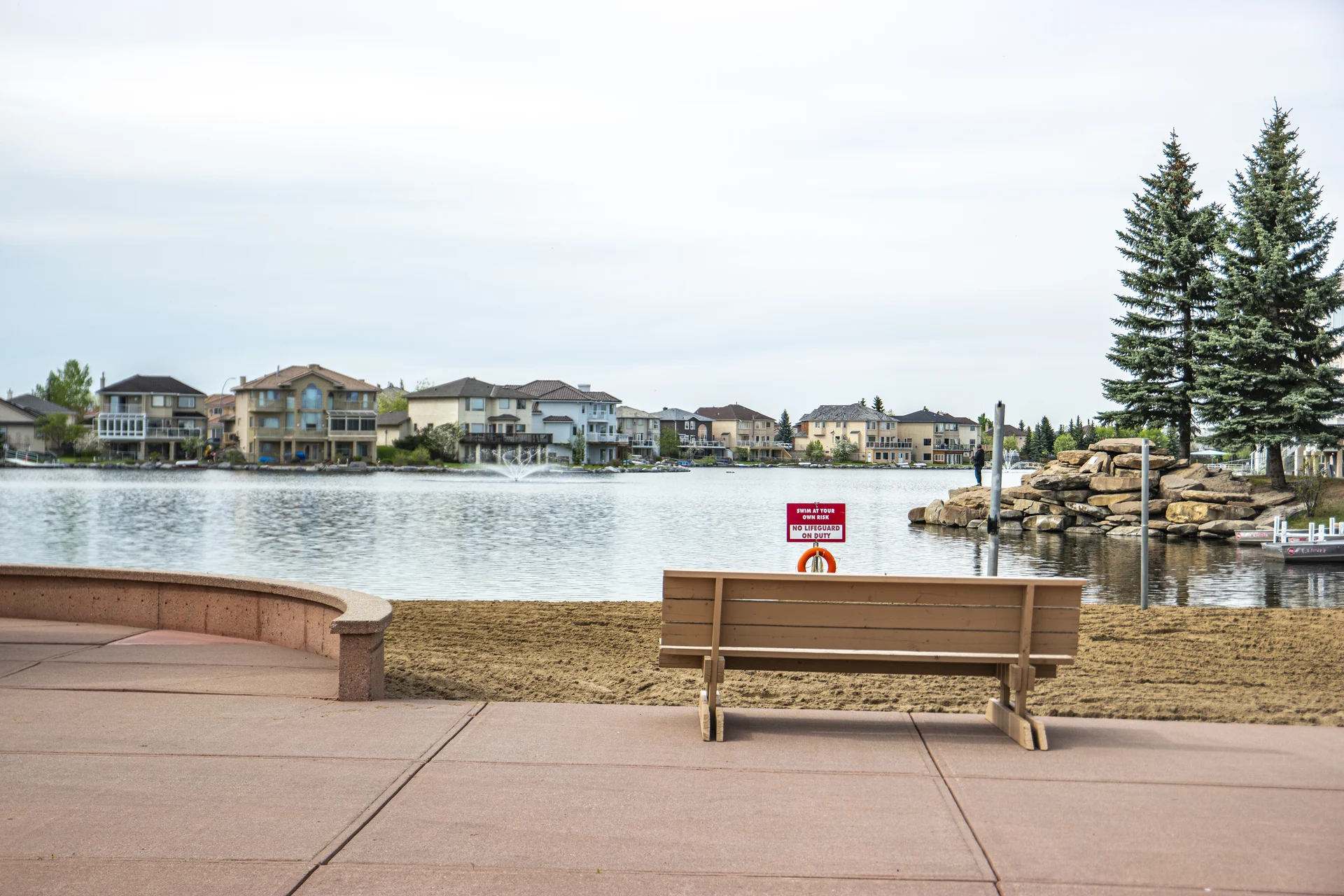Photograph of Coral Springs lake, sandy beach, pink terrace, fountain and spruce-lined shore