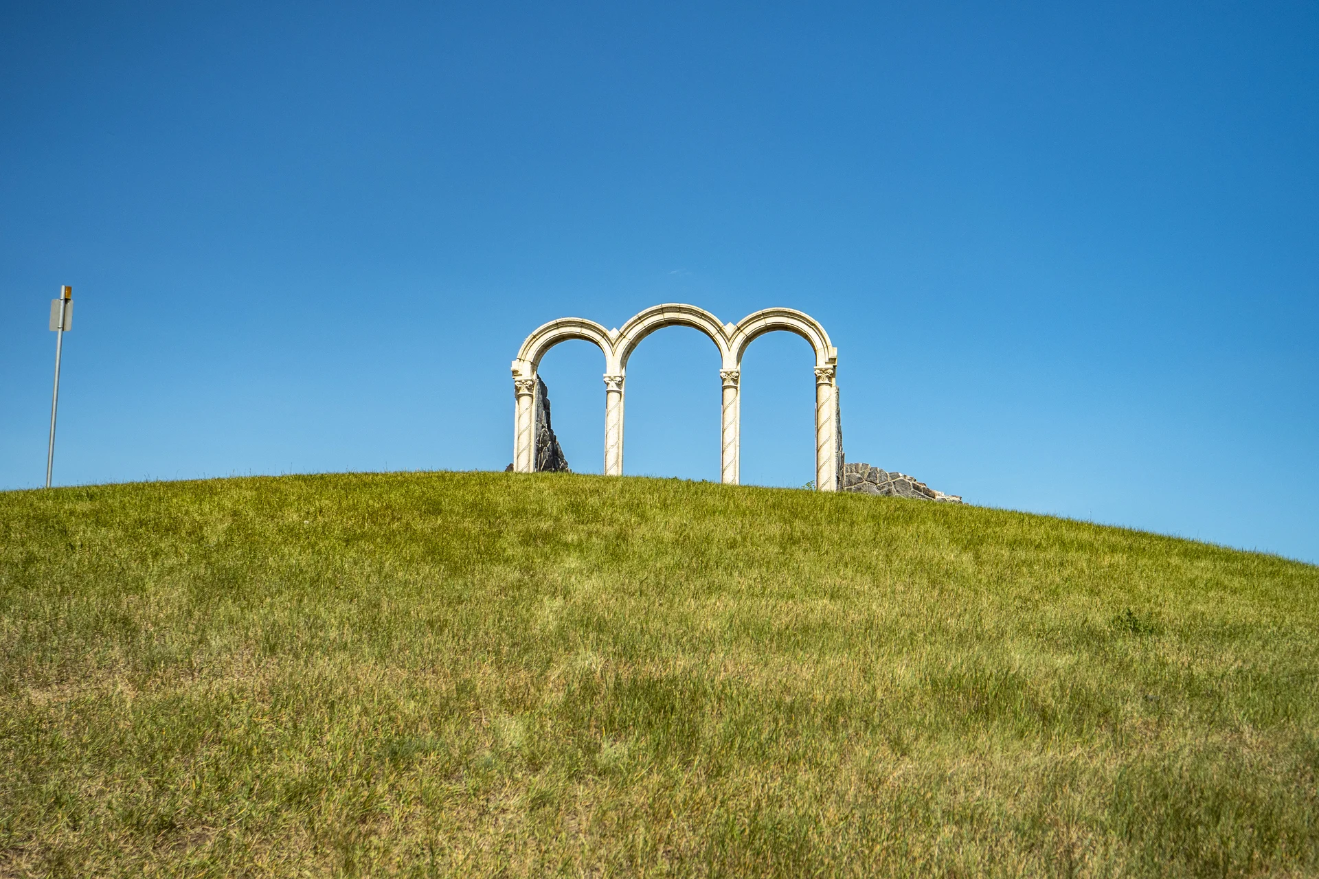 Photograph of McKenzie Towne three stone arches on their grassy hill